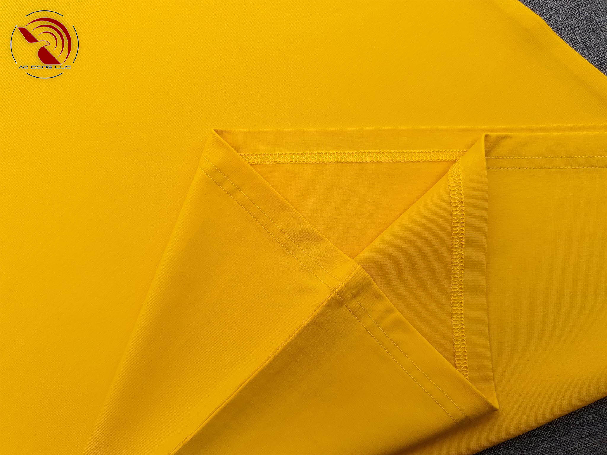 Chi tiết vạt áo áo thun cổ tròn ngắn tay cotton cao cấp màu vàng đậm