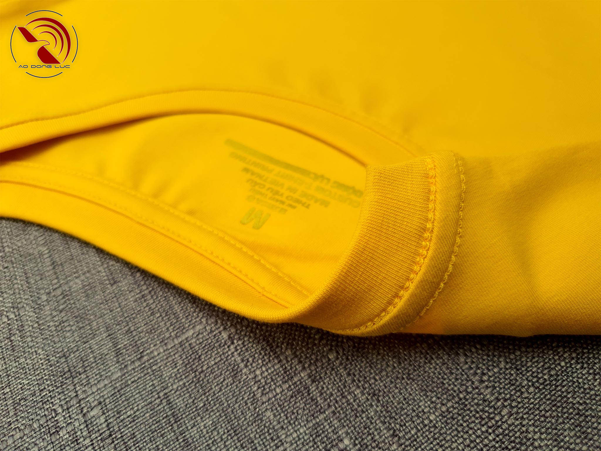 Chi tiết đường may móc xích cổ áo thun cổ tròn cotton cao cấp màu vàng đậm