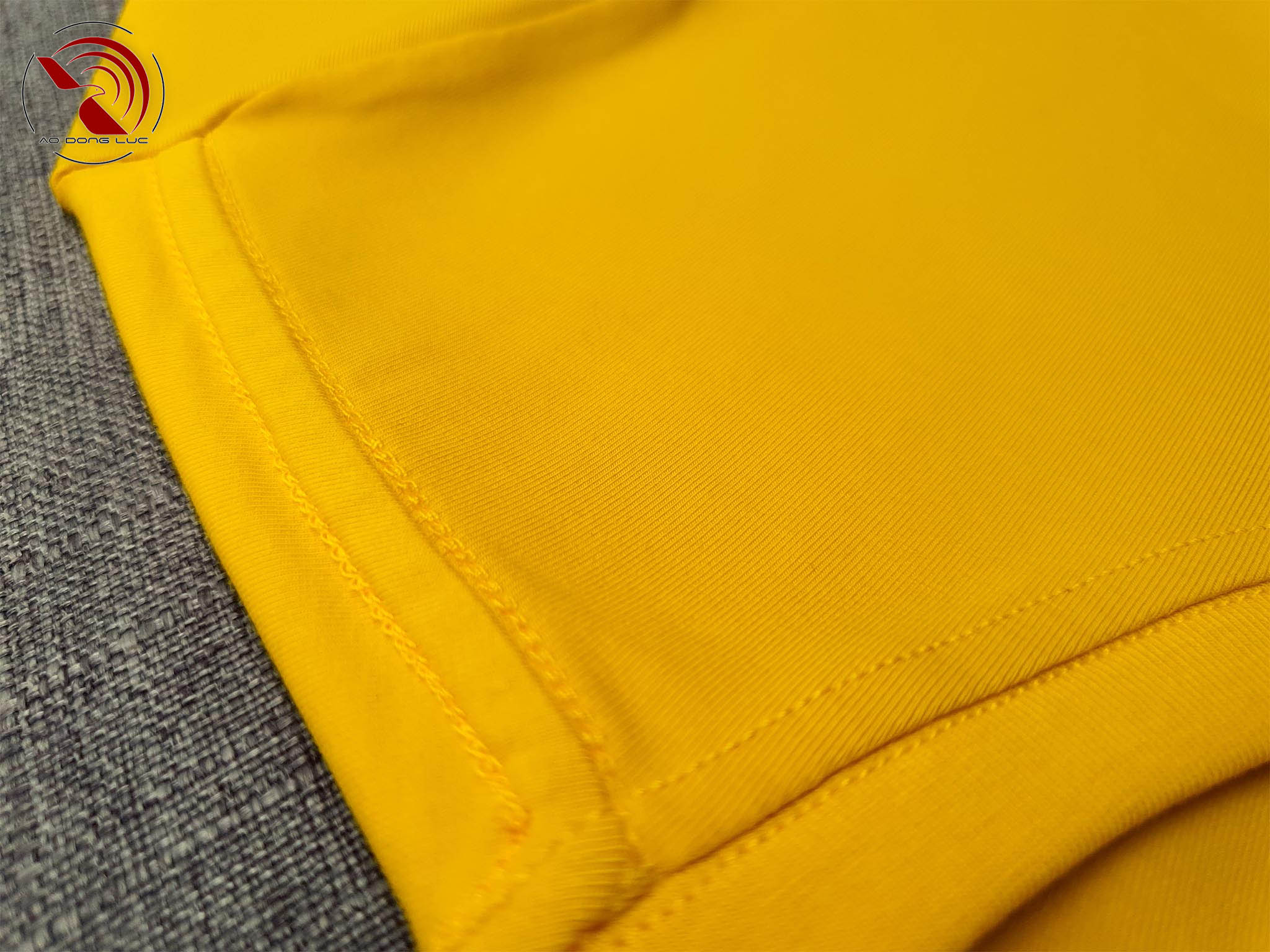 Chi tiết đường may móc xích vai áo thun cổ tròn cotton cao cấp màu vàng đậm