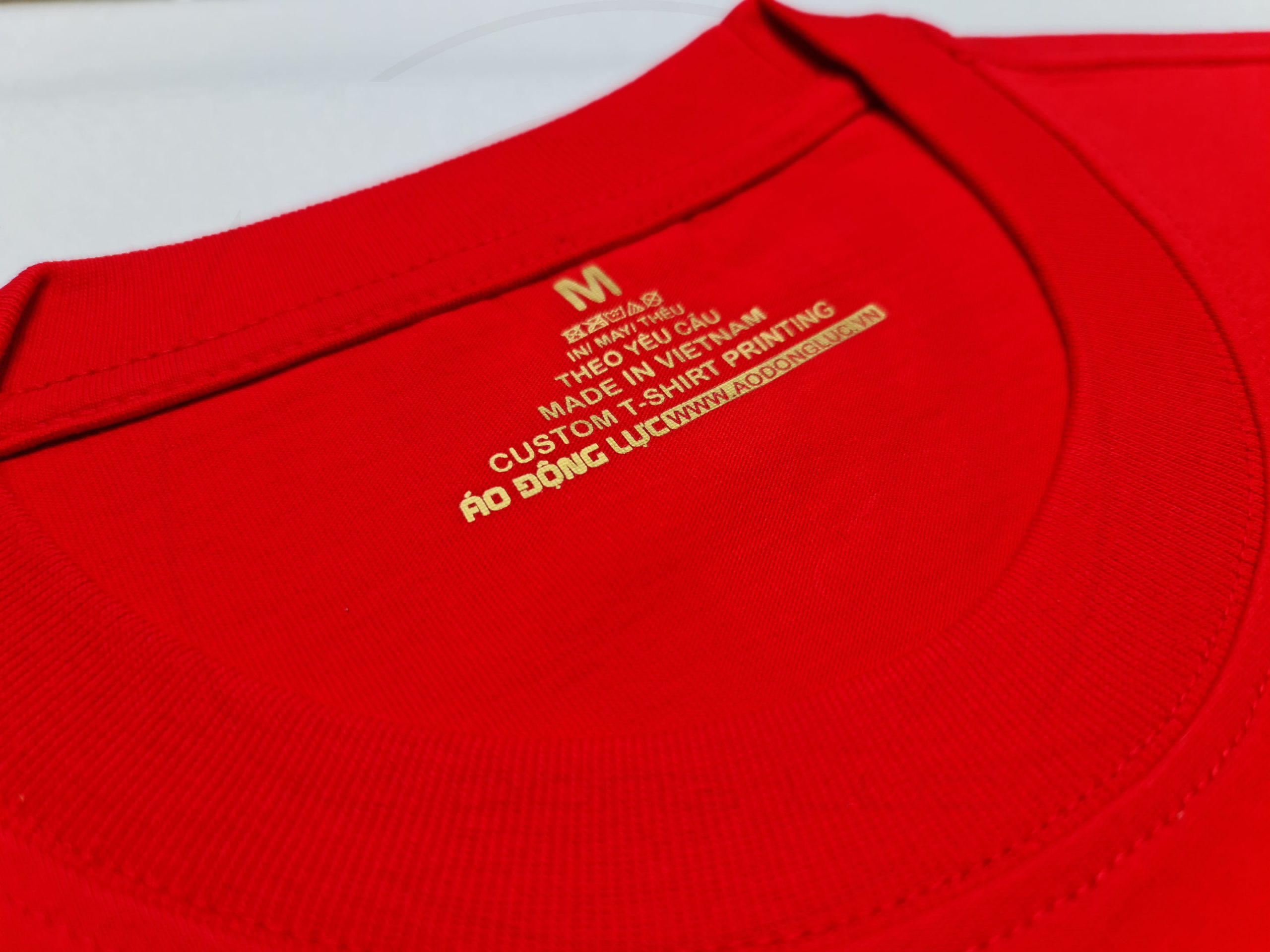 Chi tiết đường may và cổ áo áo thun cổ tròn tay lỡ oversize màu đỏ tươi