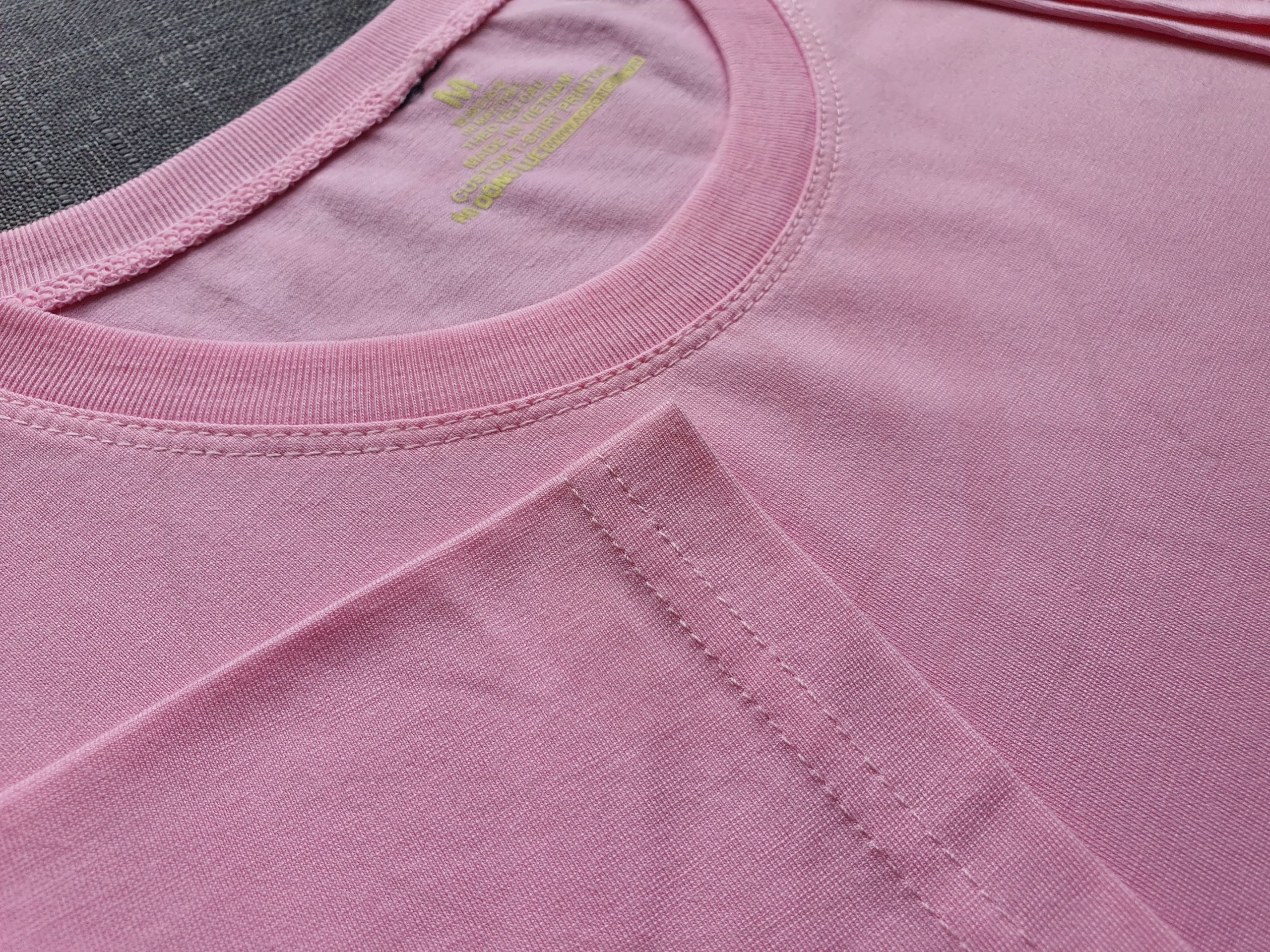 Hình chụp chi tiết đường may áo thun cổ tròn ngắn tay supe unisex màu hồng phấn