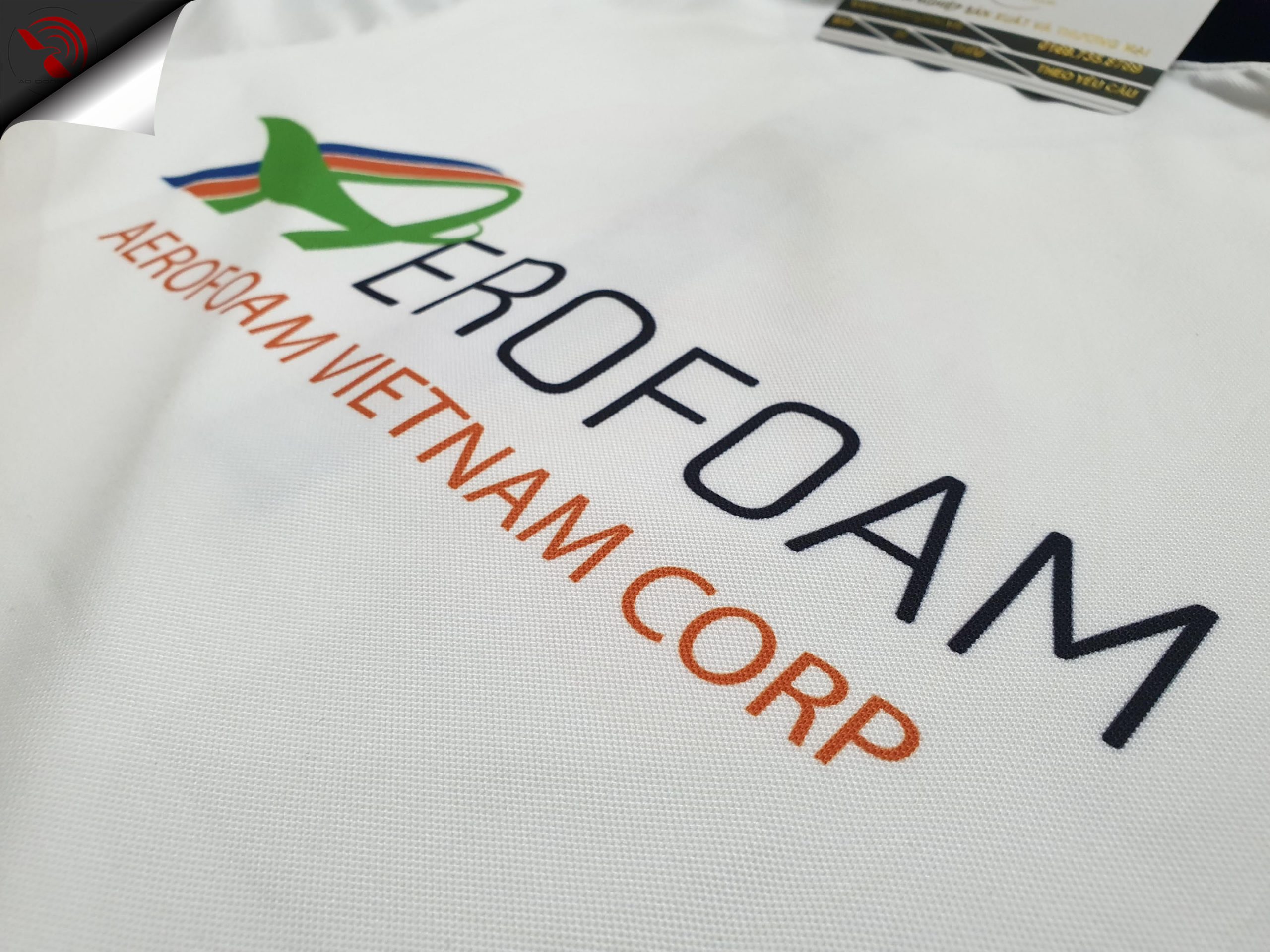 Hình in chuyển nhiệt lên áo thun đồng phục polo màu trắng phối xanh bích