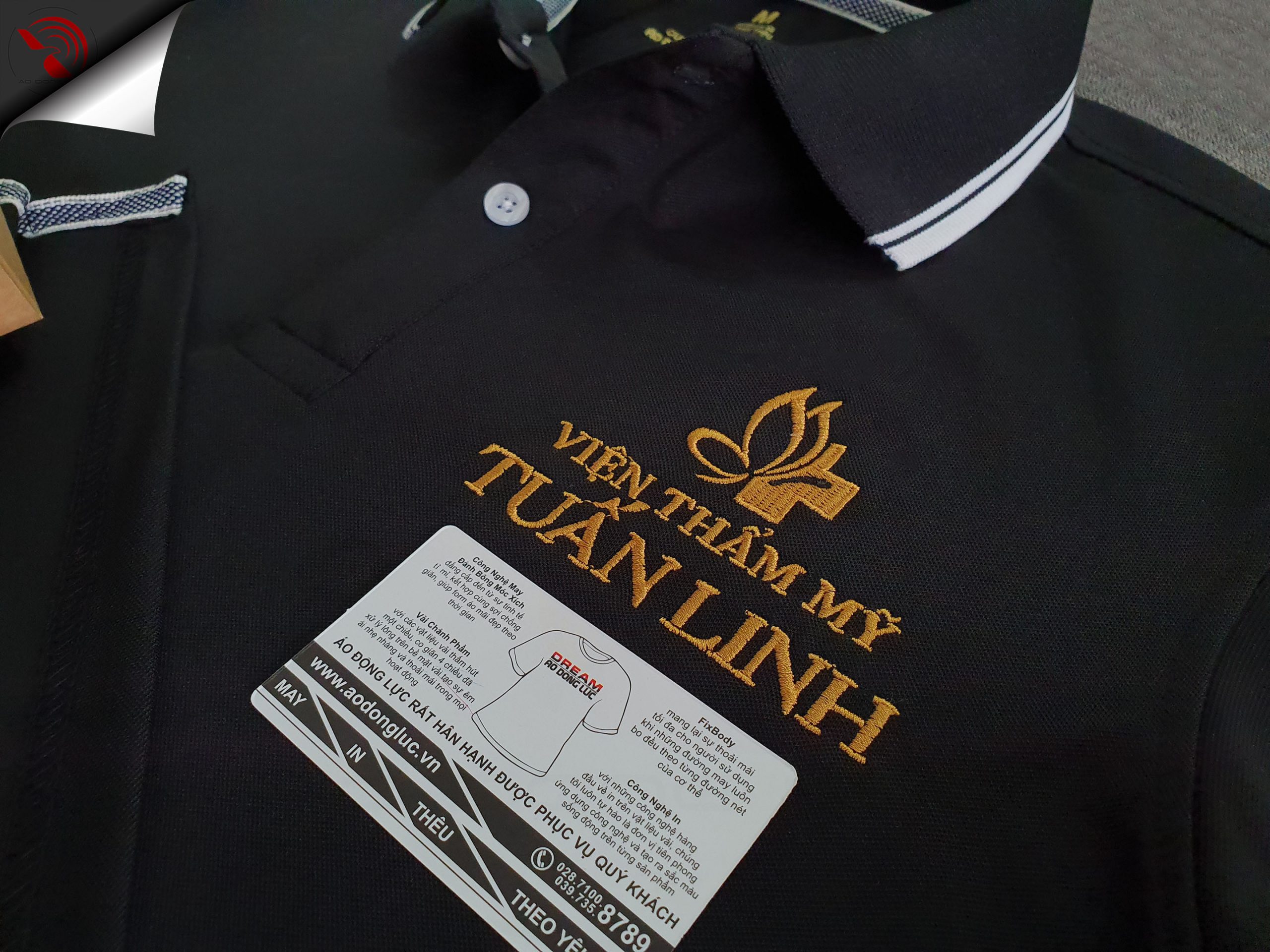 Hình thêu logo lên áo thun đồng phục polo màu đen dệt bo theo yêu cầu
