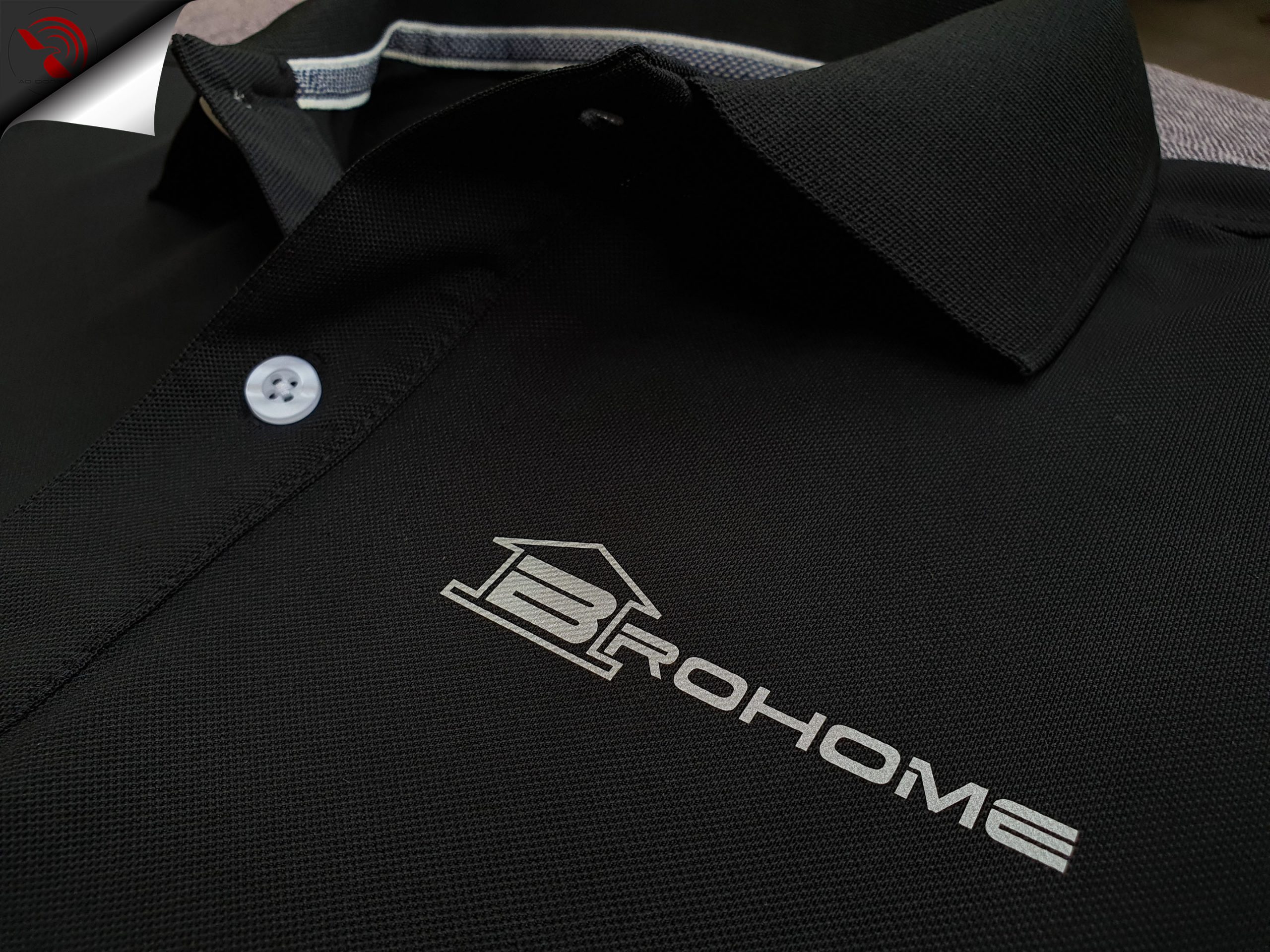Hình in phản quang logo lên áo thun đồng phục polo bo trơn màu đen