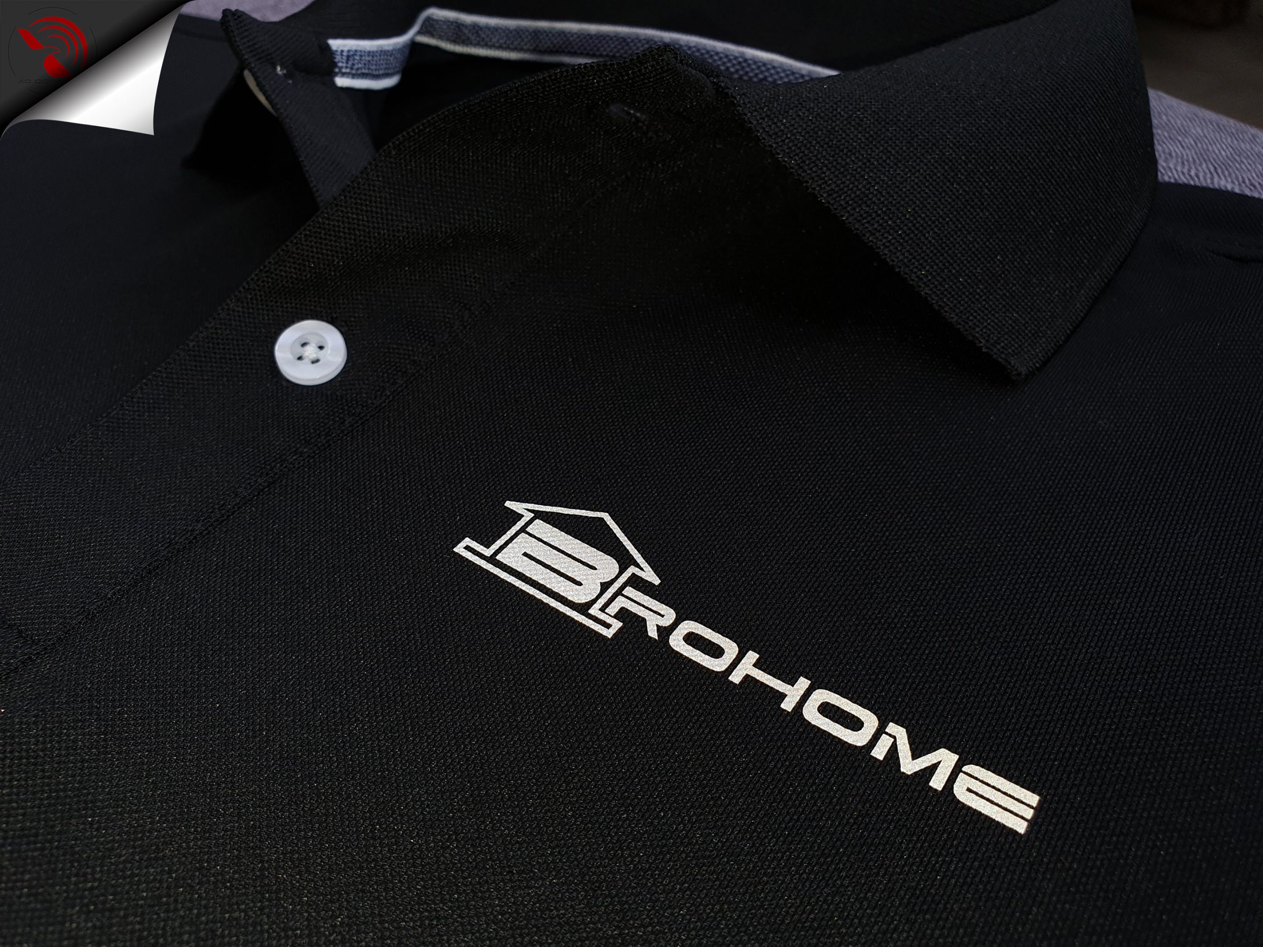 Hình in phản quang logo lên áo thun đồng phục polo bo trơn màu đen